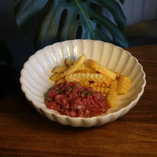 Тартар из говядины с картофелем фри и соусом из анчоусов и корнишонов